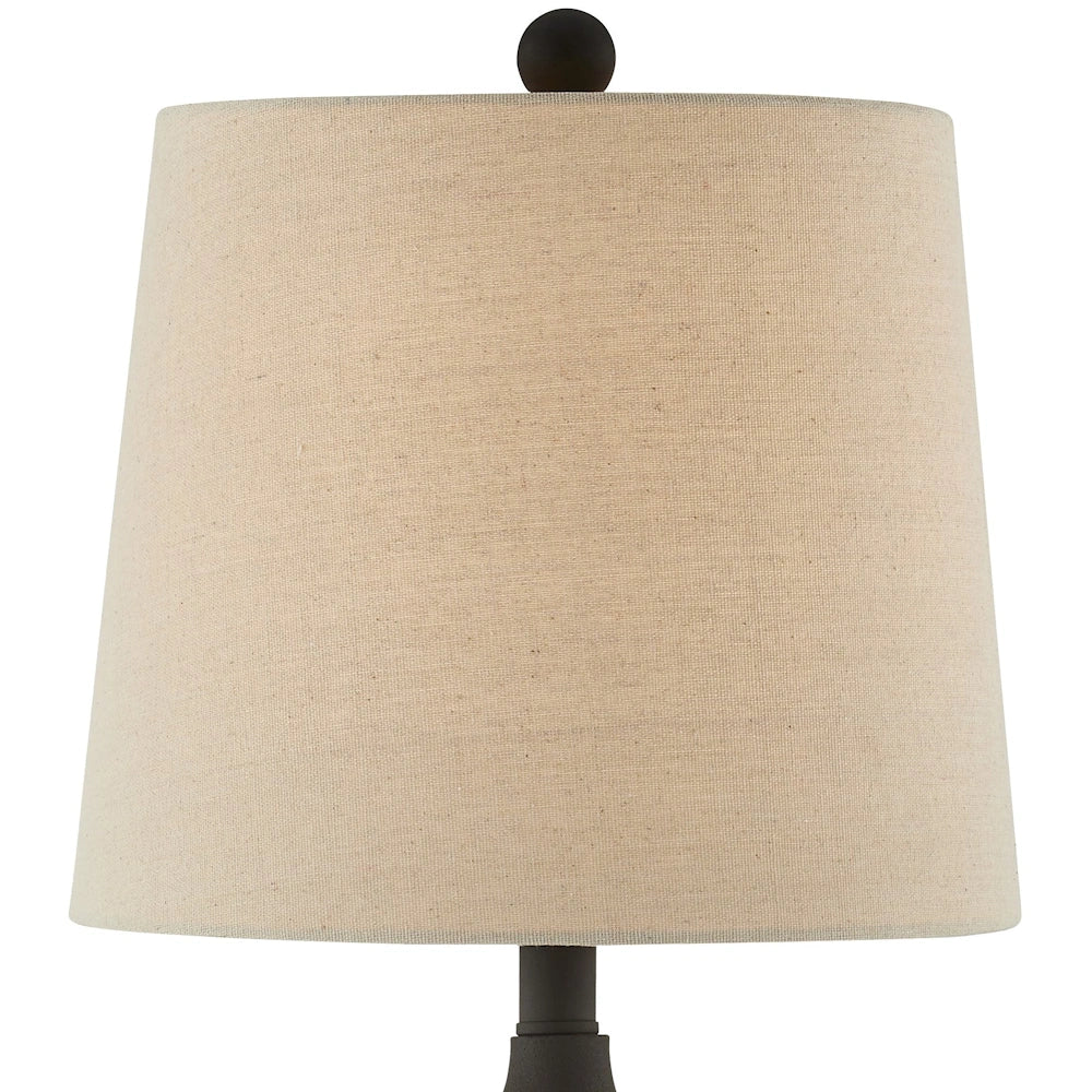 Close up of beige tapered fabric shade on black metal buffet table lamp with round finial.