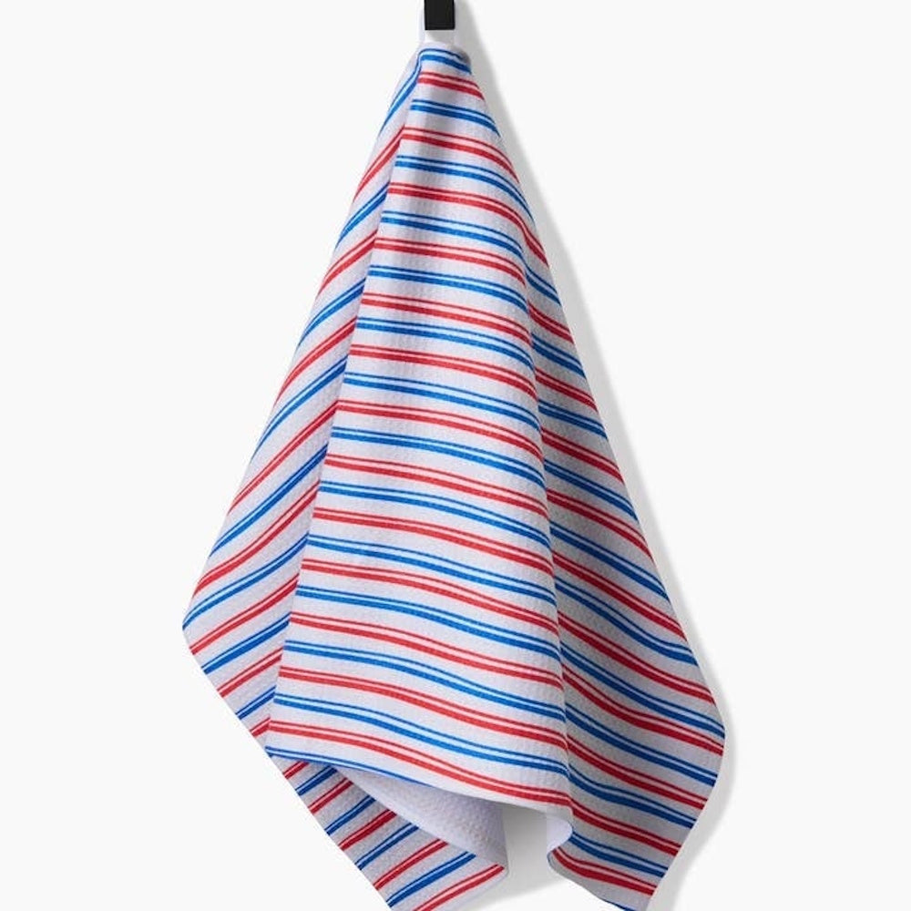 A kitchen tea towel with a waffle-weave texture featuring horizontal red and blue stripes on a white background.