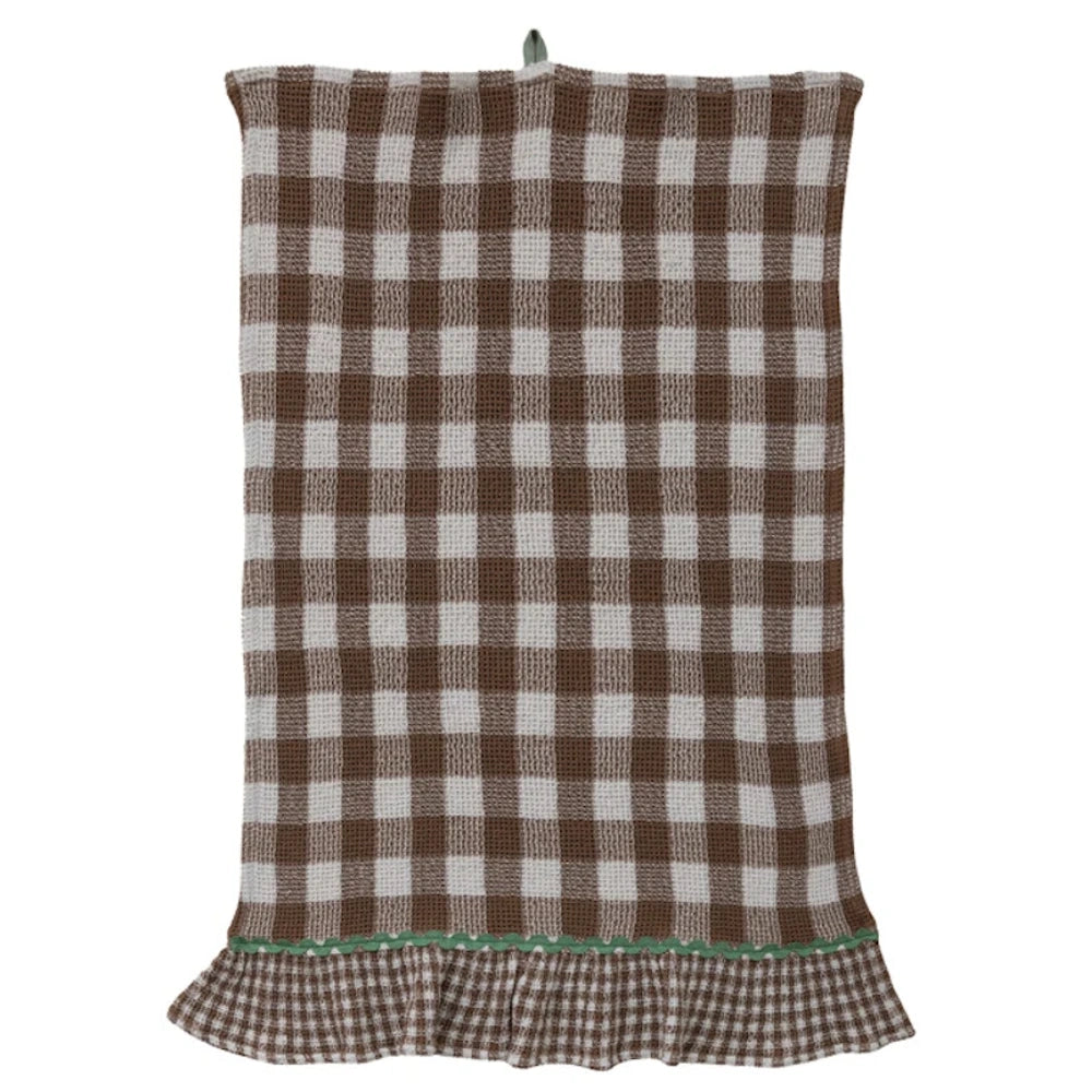 Brown and white buffalo check waffle-weave kitchen towel with a green ric-rac trim and ruffled hem.