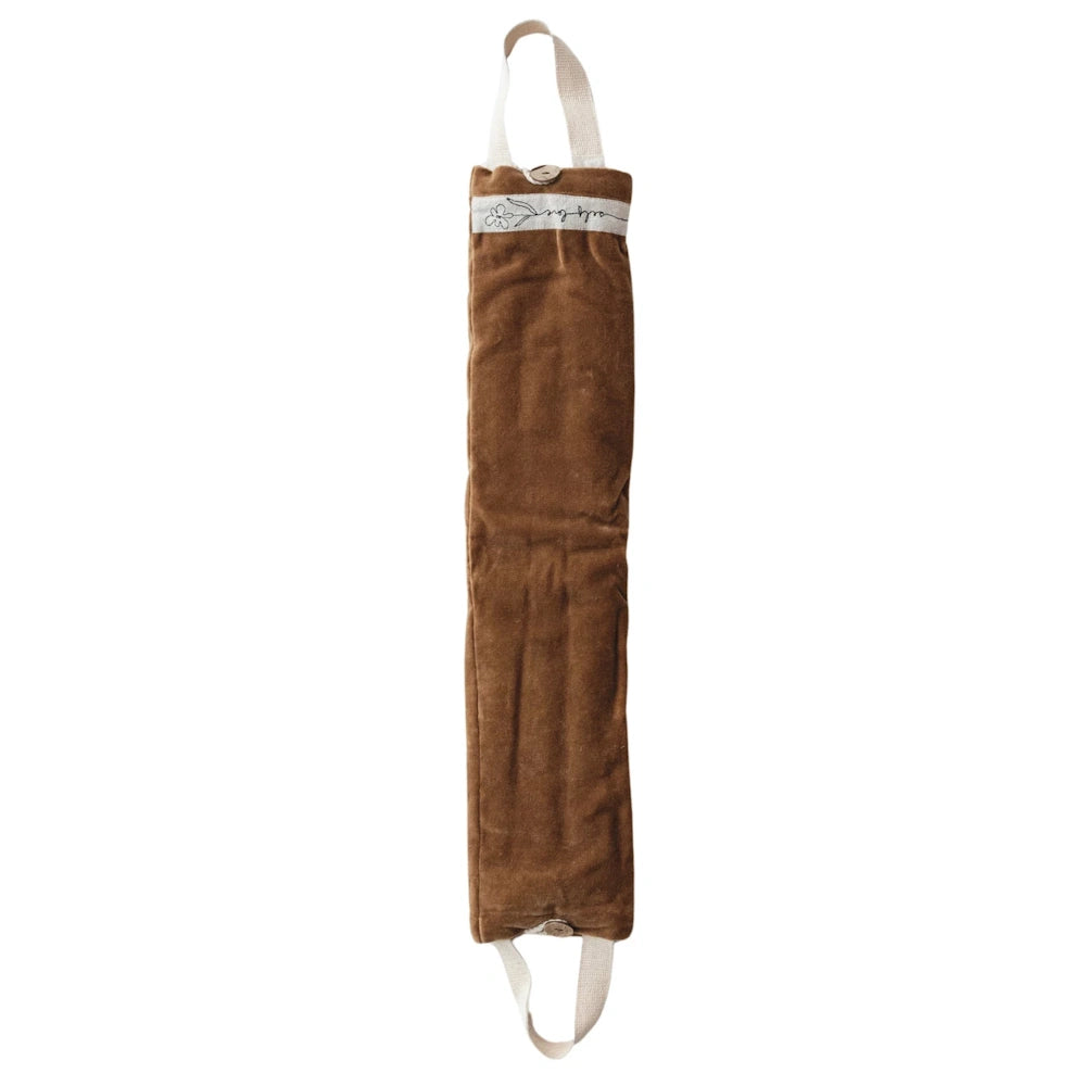 Brown velvet microwaveable hot and cold neck wrap with cream handles and button closure on a white background.