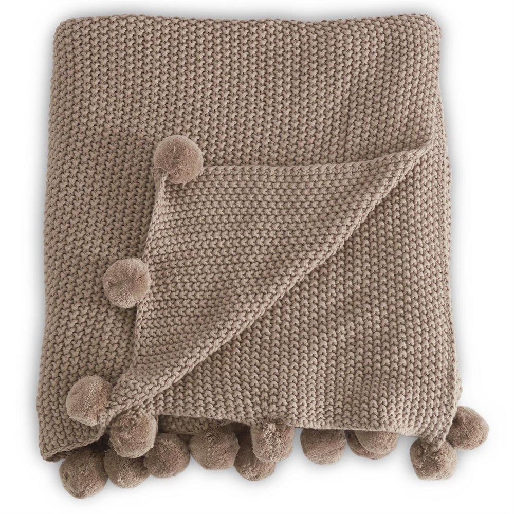Textured brown knit throw blanket with decorative pom-pom trim, folded neatly on a white background.