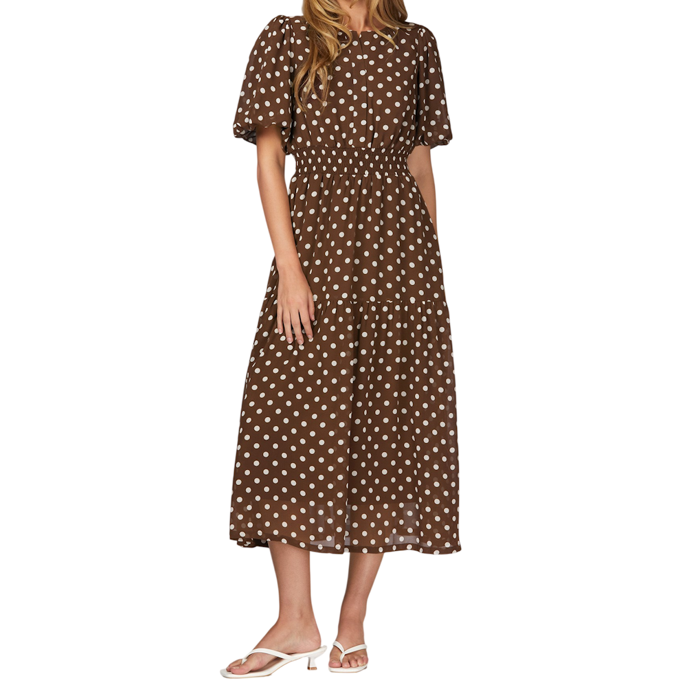 Brown polka dot tiered midi dress with short puff sleeves and smocked waist, paired with white heeled sandals.