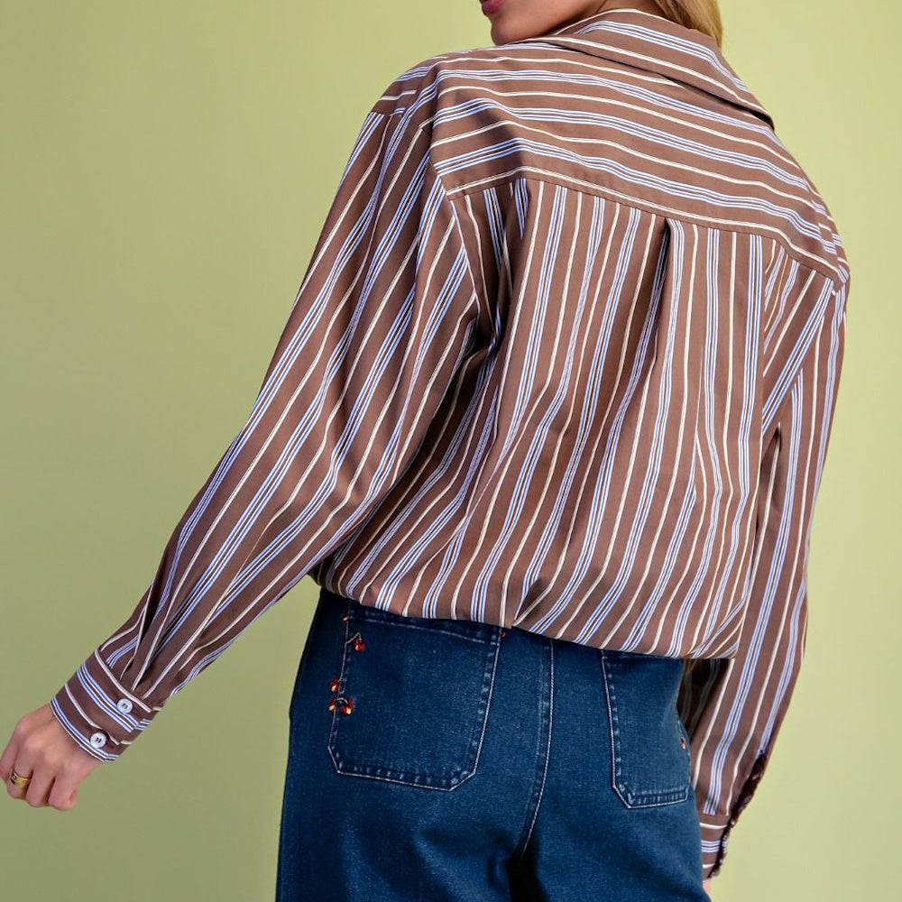 Back view of a brown button-down shirt with vertical white and blue stripes.