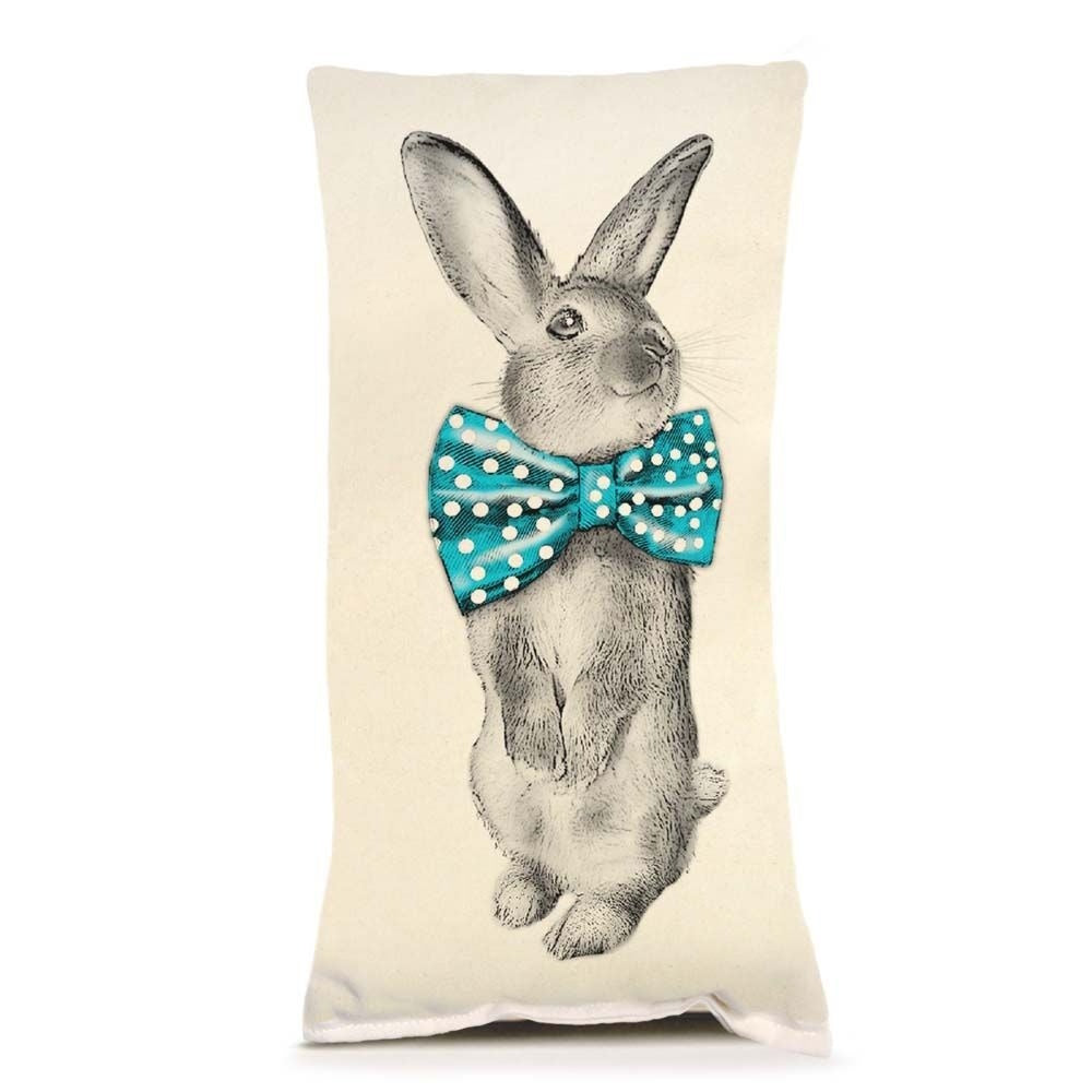A rectangular pillow featuring a sketch of a standing rabbit wearing a bright teal polka-dot bowtie.