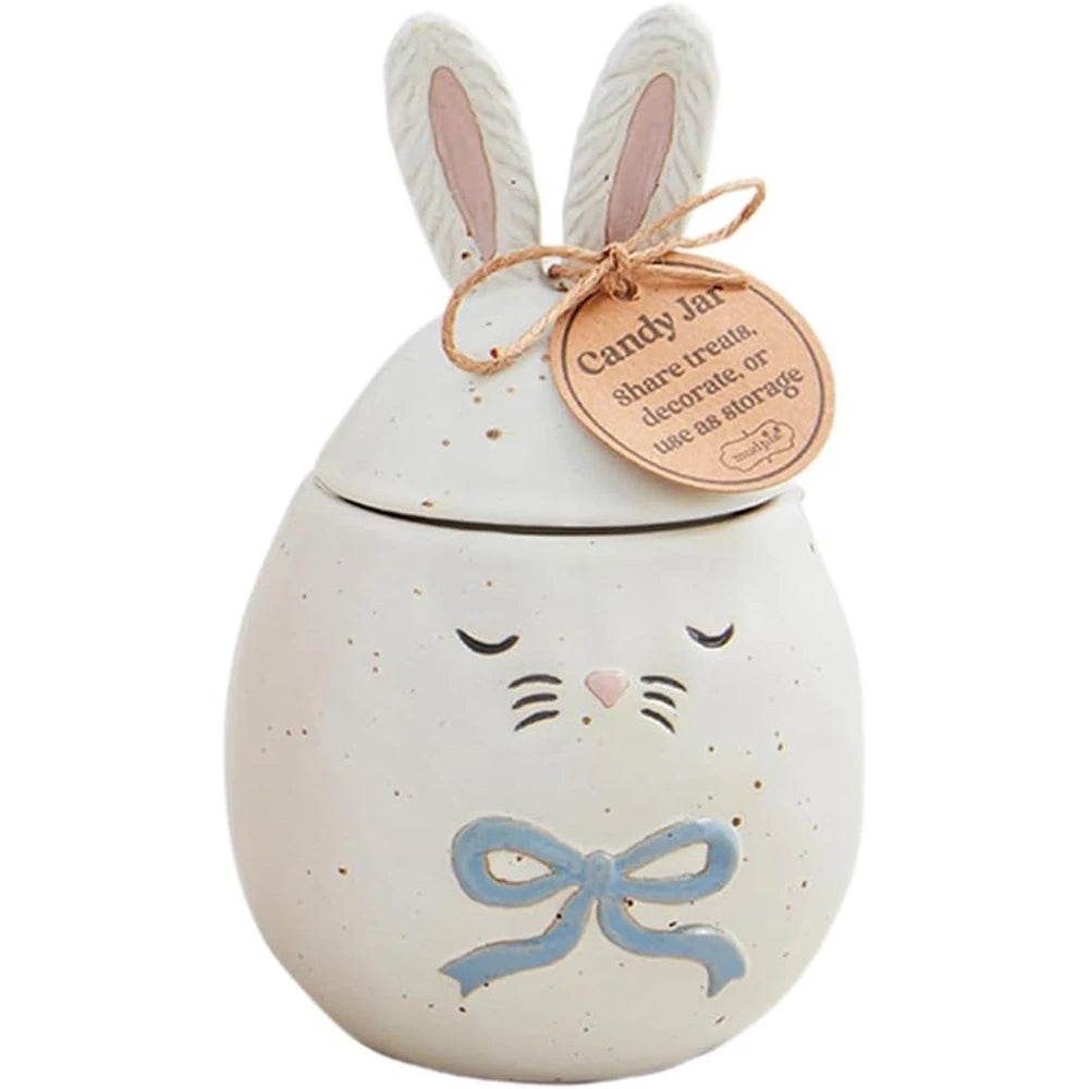 Egg-shaped ceramic bunny candy jar with a blue bow, sleeping eyes, and tall ears tied with a tag.