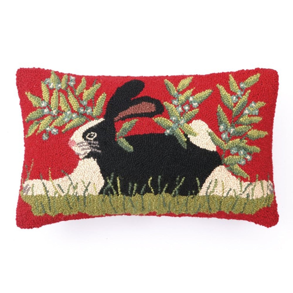 Hand-hooked wool pillow featuring a black and white bunny in a garden on a vibrant red background.