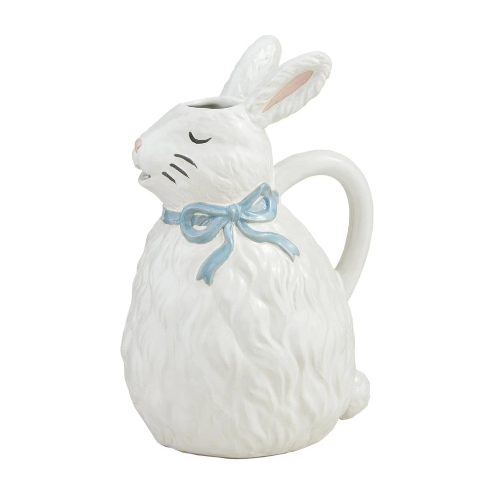 White ceramic bunny pitcher with a blue bow tied around its neck.
