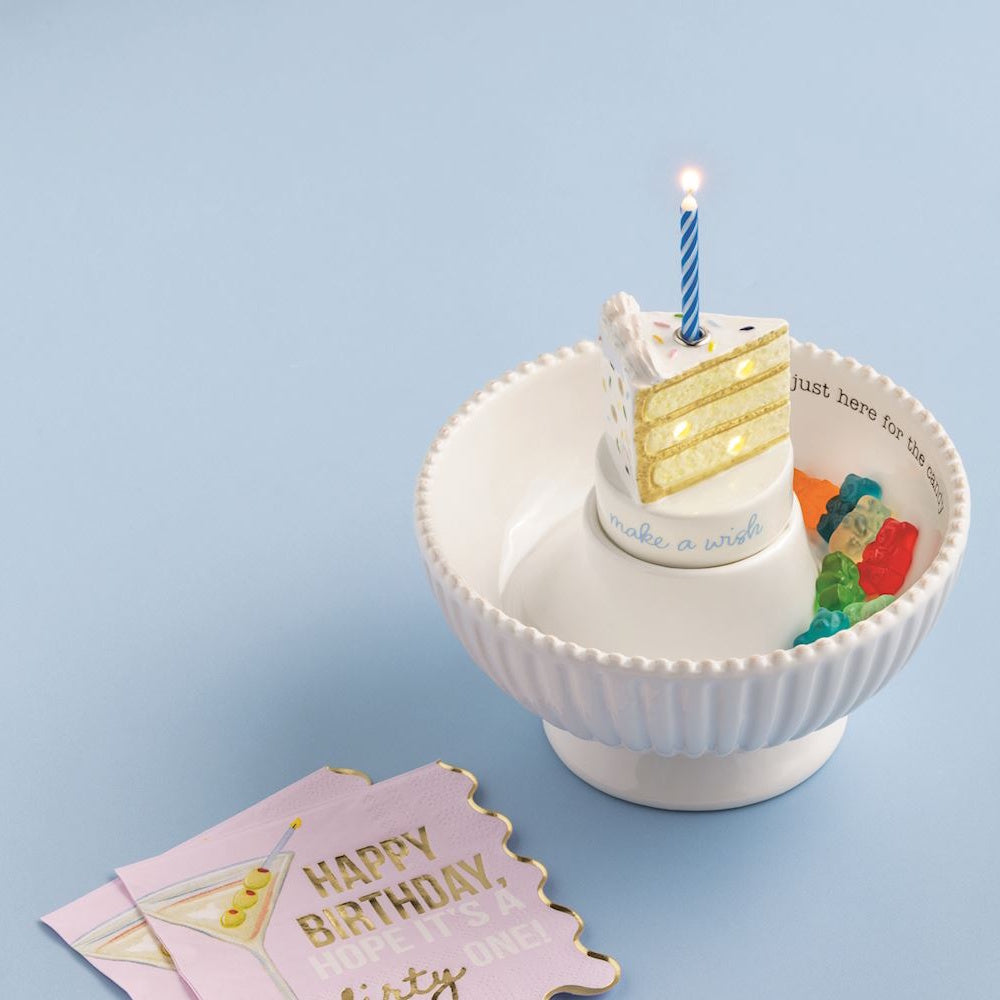 Light-up cake slice candle holder sitter in a white candy bowl with "make a wish" text and colorful gummy bears.