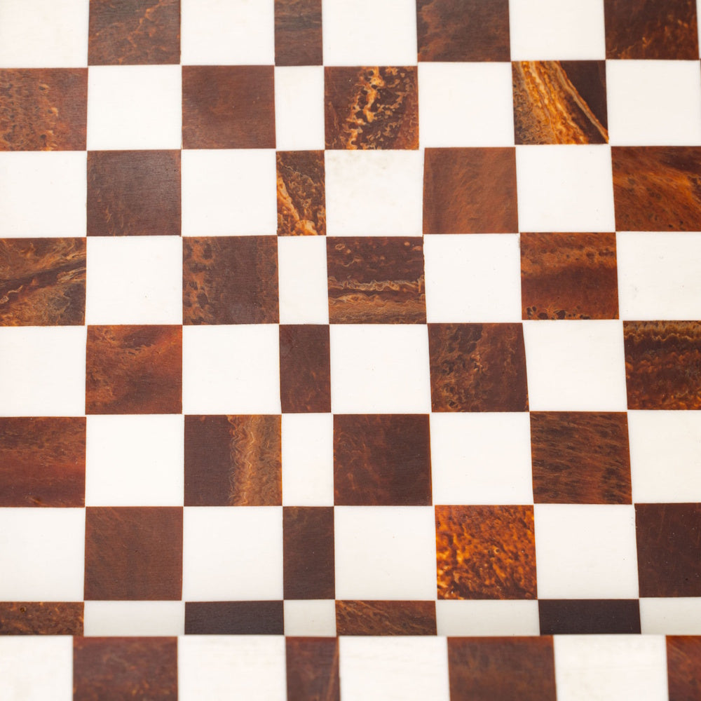Close-up of a checkered pattern tray with brown marbled and white squares for a sophisticated, modern home decor look.