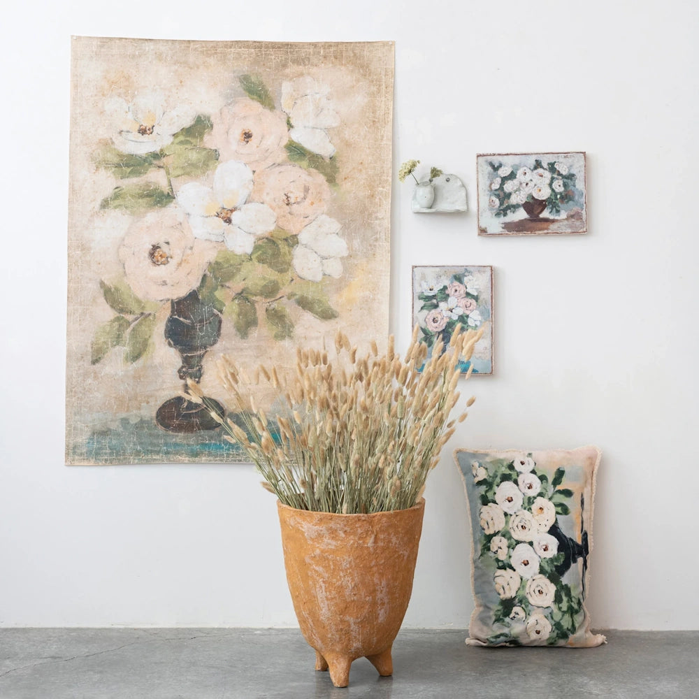 Vintage floral canvas wall art set with matching pillow and dried grass in a terracotta pot for rustic home decor.