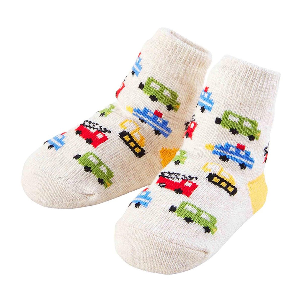 Pair of cream baby socks featuring colorful vehicle patterns against a white background.