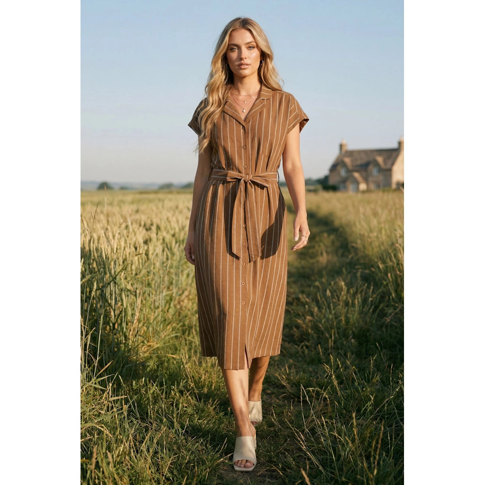 Caramel brown striped short sleeve midi shirt dress with tie waist on a woman in a field.