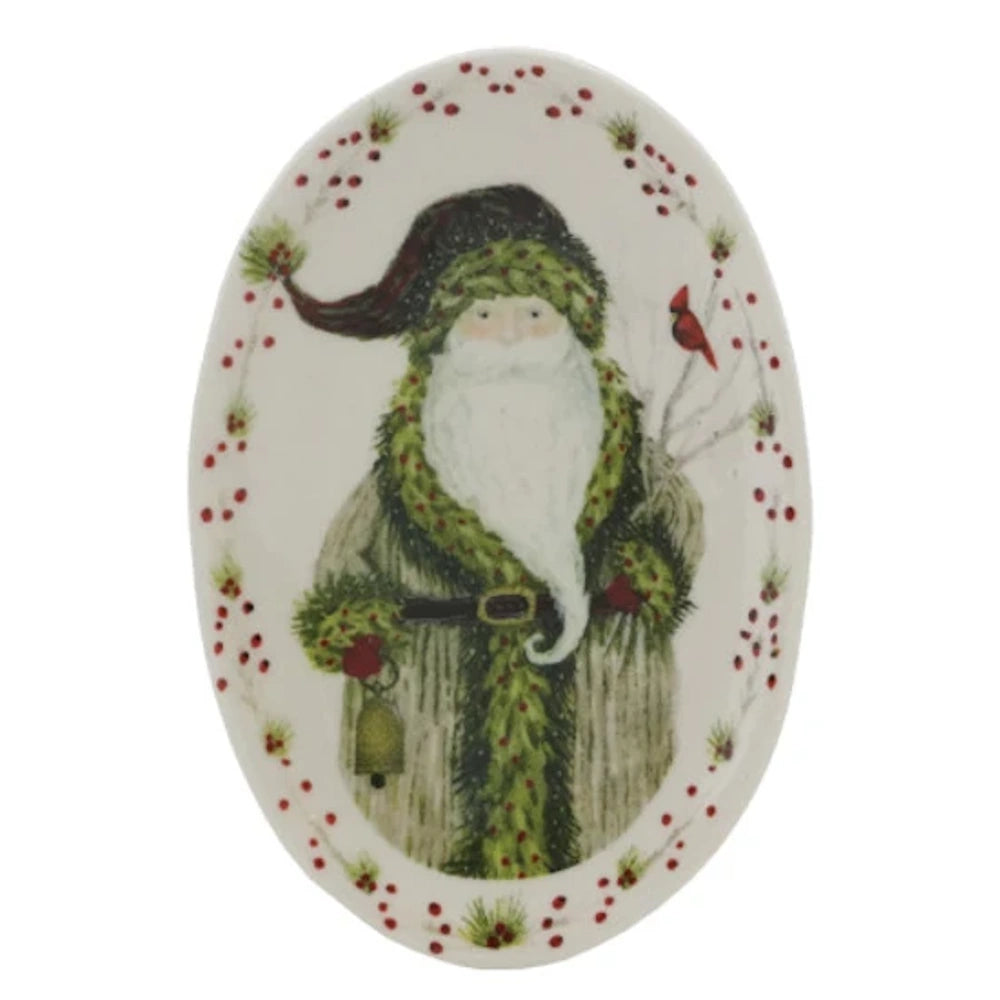 An oval white platter featuring Santa holding a bell, with a red cardinal perched on a branch nearby.