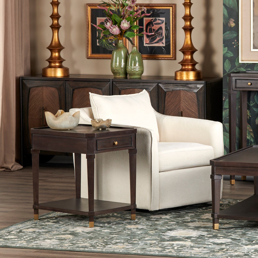 Modern living room with cream swivel chair, dark wood end table, and patterned rug in an elegant interior setting.