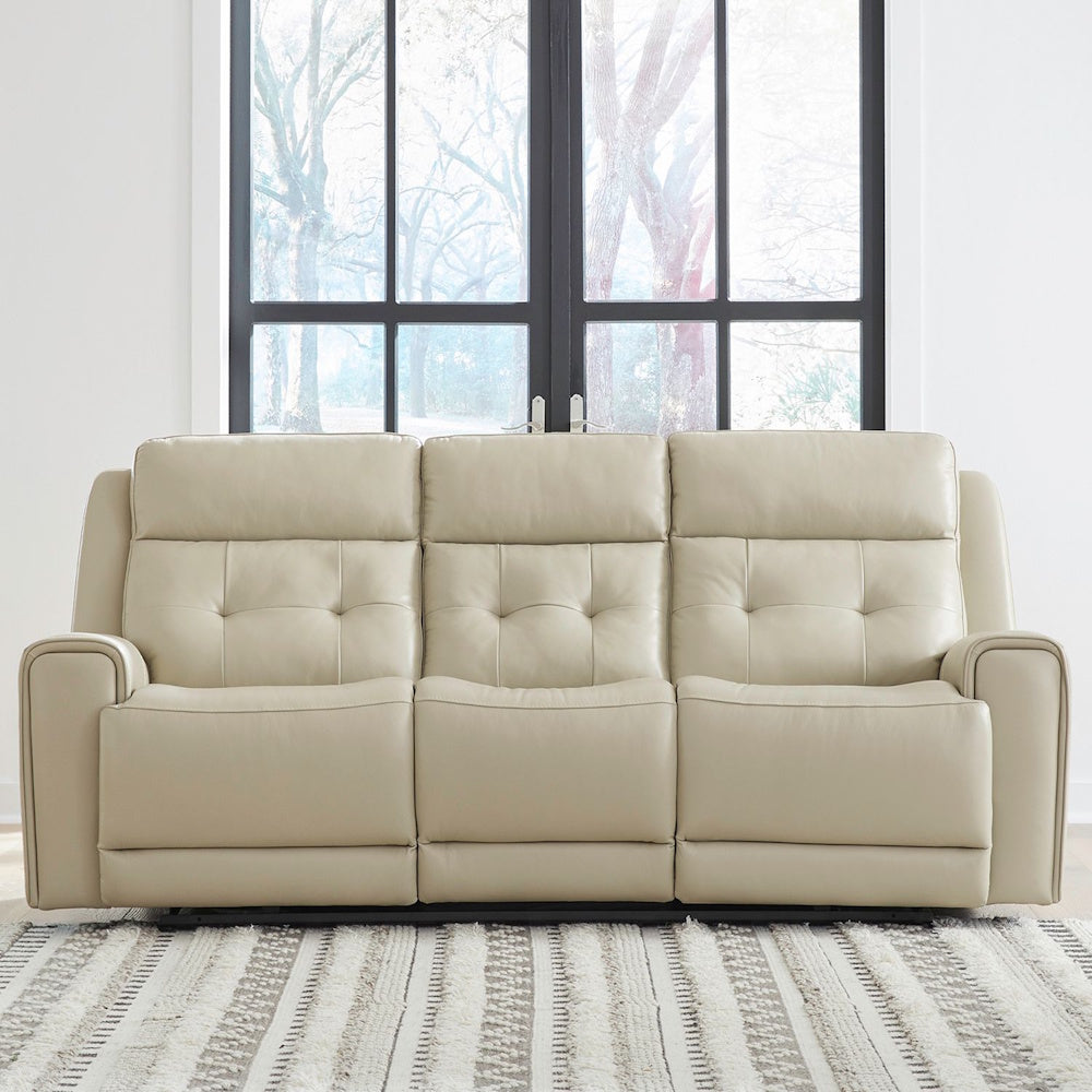 Cream leather power reclining sofa in modern living room with tufted backs and plush padded seating comfort.