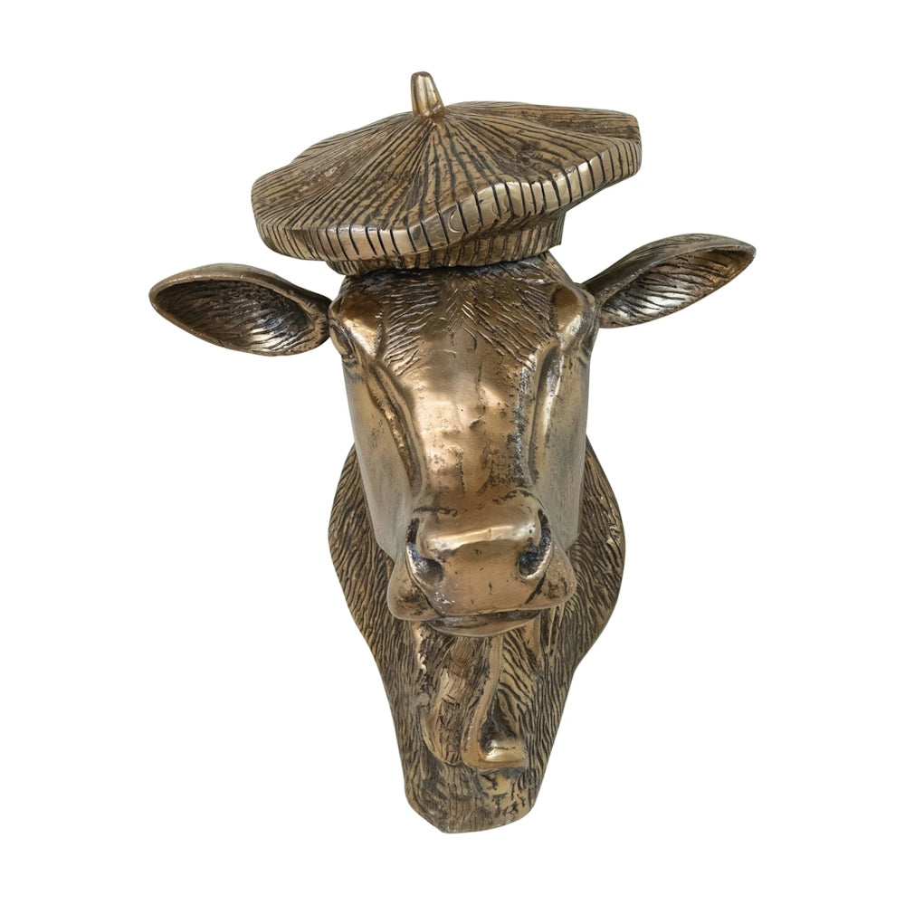 Front view of a bronze metallic cow head wall decor wearing a textured beret, against a plain white background.