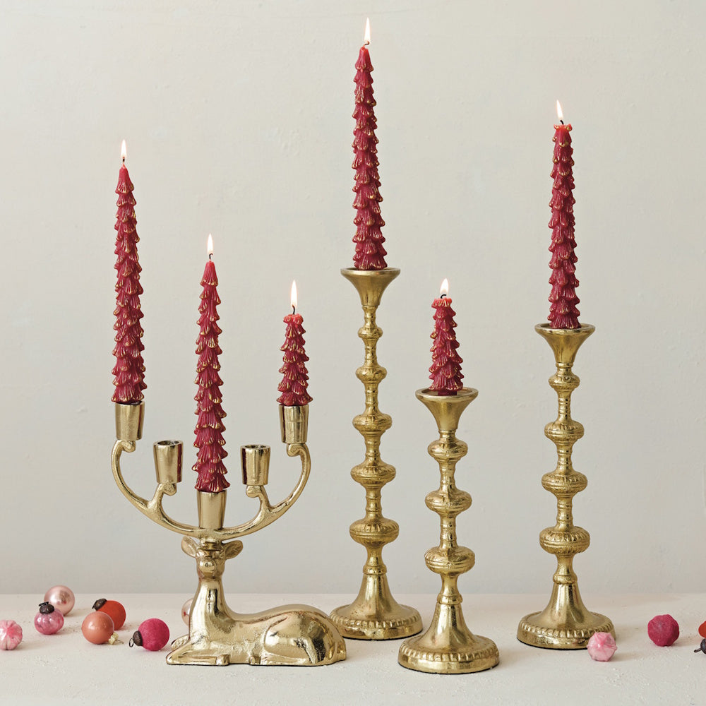 Gold deer candelabra and matching candleholders lit with red tree-shaped candles.