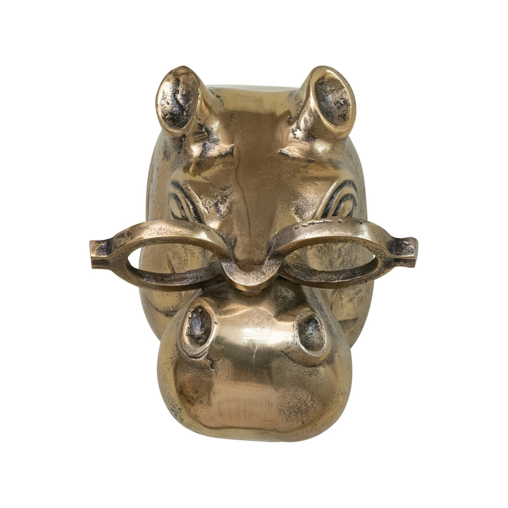 Front view of a metallic brass hippo head wall sculpture wearing eyeglasses on a white background.