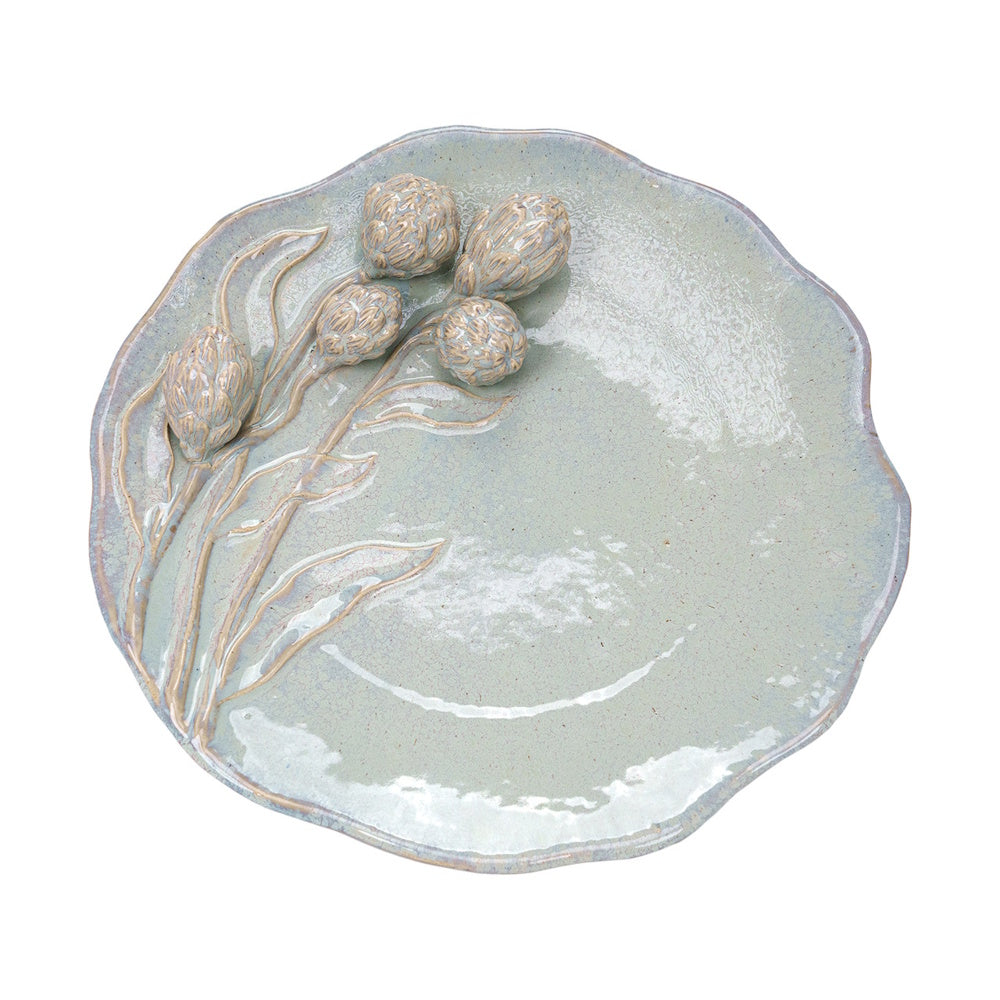 Pale green ceramic platter with a scalloped edge and raised 3D artichoke floral designs on the side.