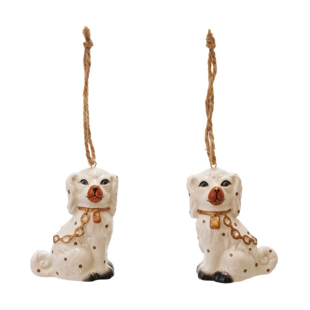Pair of white ceramic Staffordshire dog hanging ornaments with gold details and twine loops.
