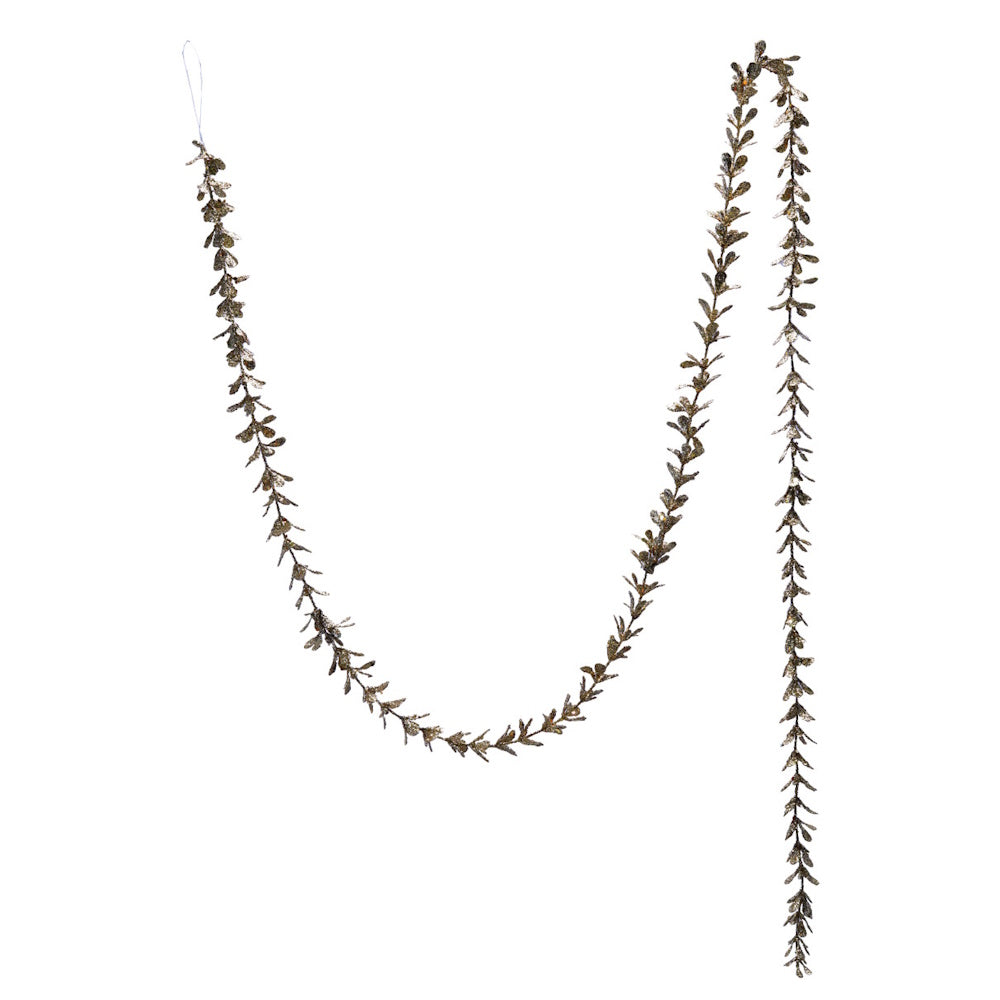 Champagne faux boxwood garland with glitter hanging against a plain white background.