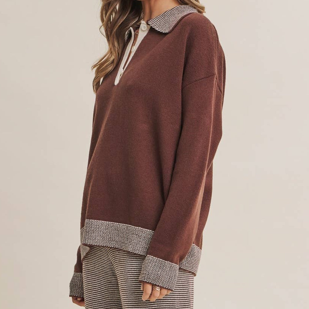 Side profile of a brown polo sweater top featuring patterned trim on the collar, hem, and cuffs.