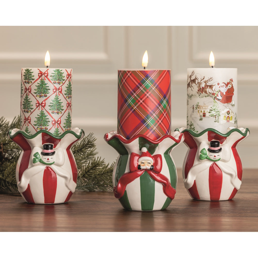 Three Christmas flameless pillar candles in ceramic holiday candle holders shown from the front.