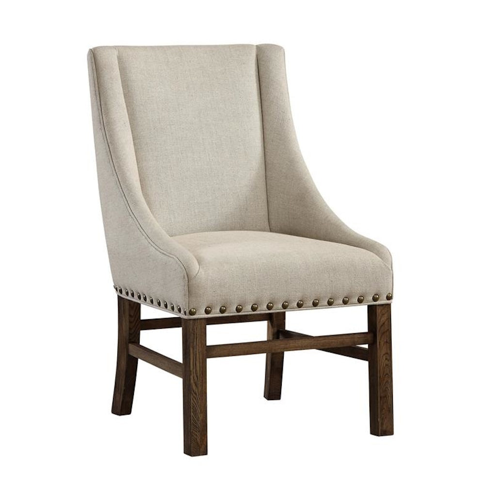 Beige linen upholstered accent chair with nailhead trim and a dark wood base.