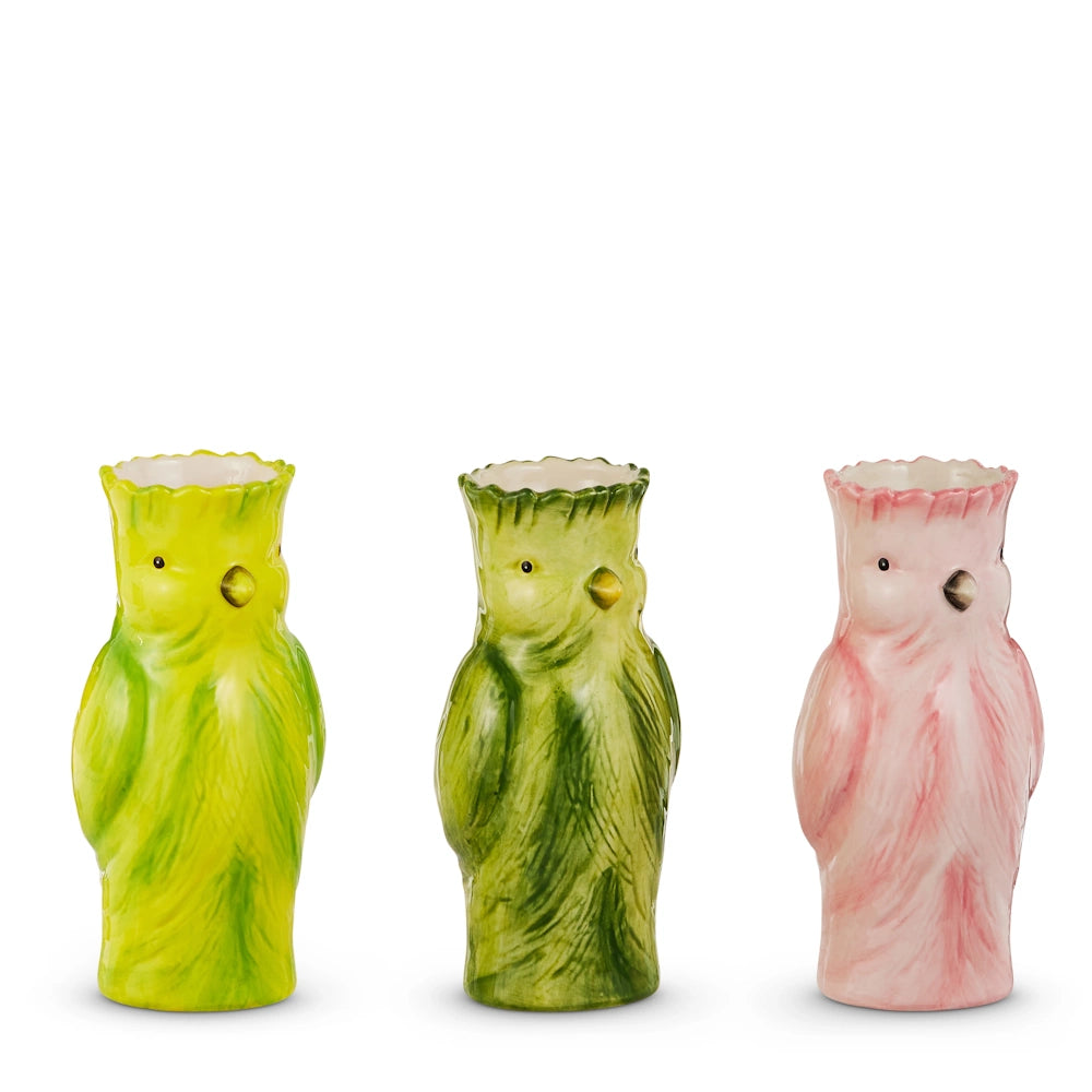 Three bird-shaped ceramic vases are aligned. The first is bright yellow-green, the second olive green, and the third pale pink, each with a glossy finish.