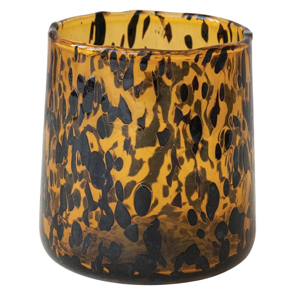 Amber hand-blown confetti glass tumbler with black tortoiseshell pattern and organic rim on white background.