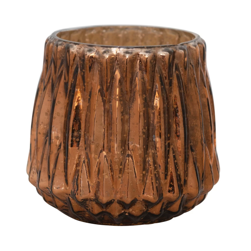 Metallic copper glass votive candle holder with textured geometric facets on a white background.