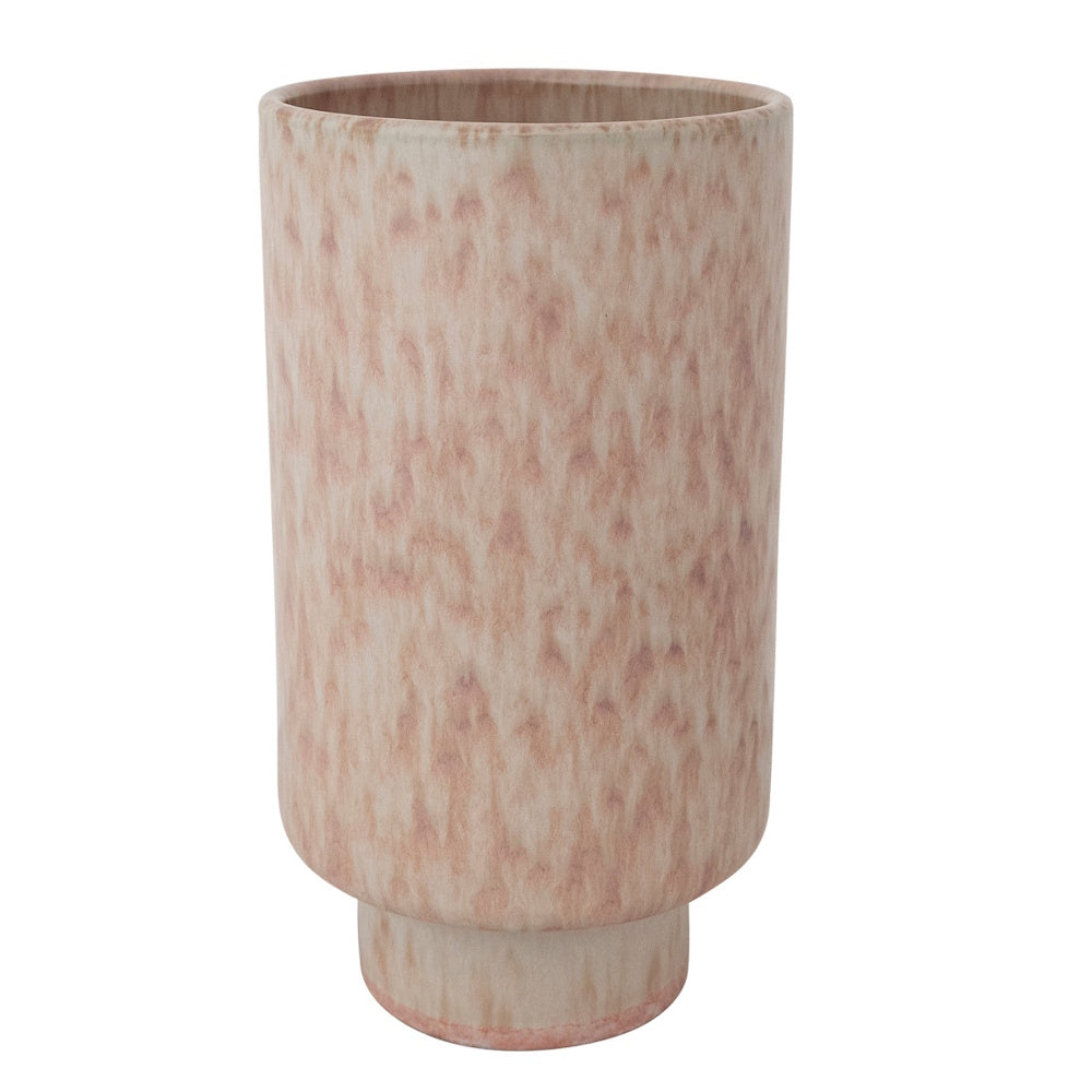 Tall coral and cream speckled stoneware vase with a footed base on a white background.