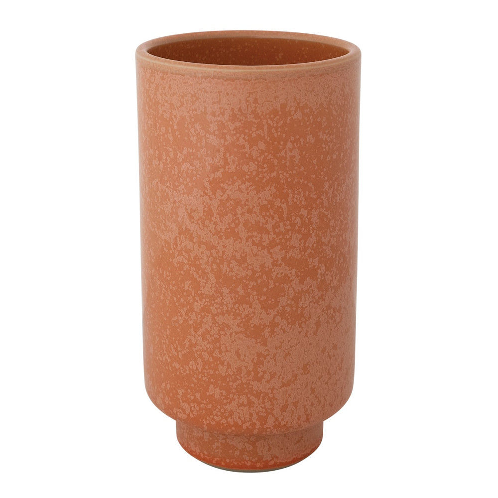 A cylindrical coral stoneware vase with a speckled texture and a small pedestal foot on white background.