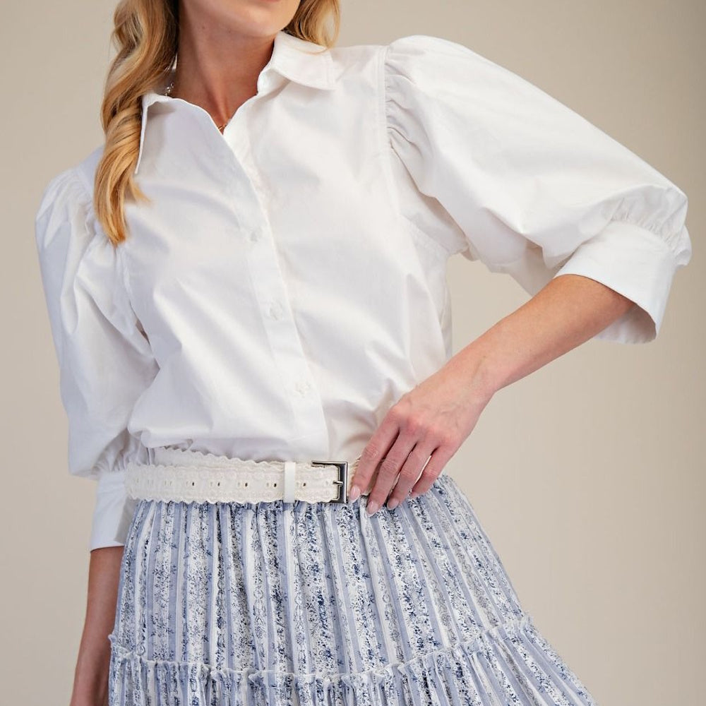 Front view of a white button-down blouse featuring voluminous puff sleeves and a classic collar.