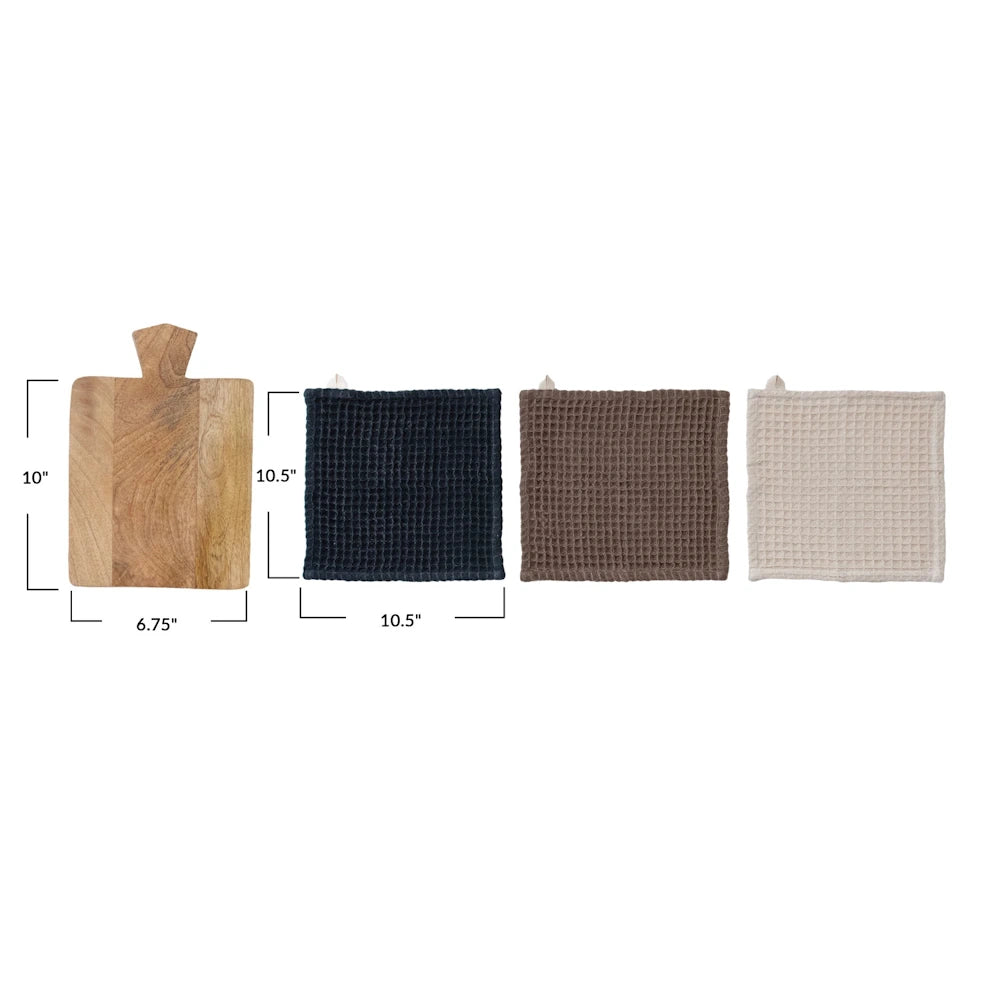 A small mango wood serving board next to three waffle-weave cotton dishcloths in black, brown, and cream with dimensions.