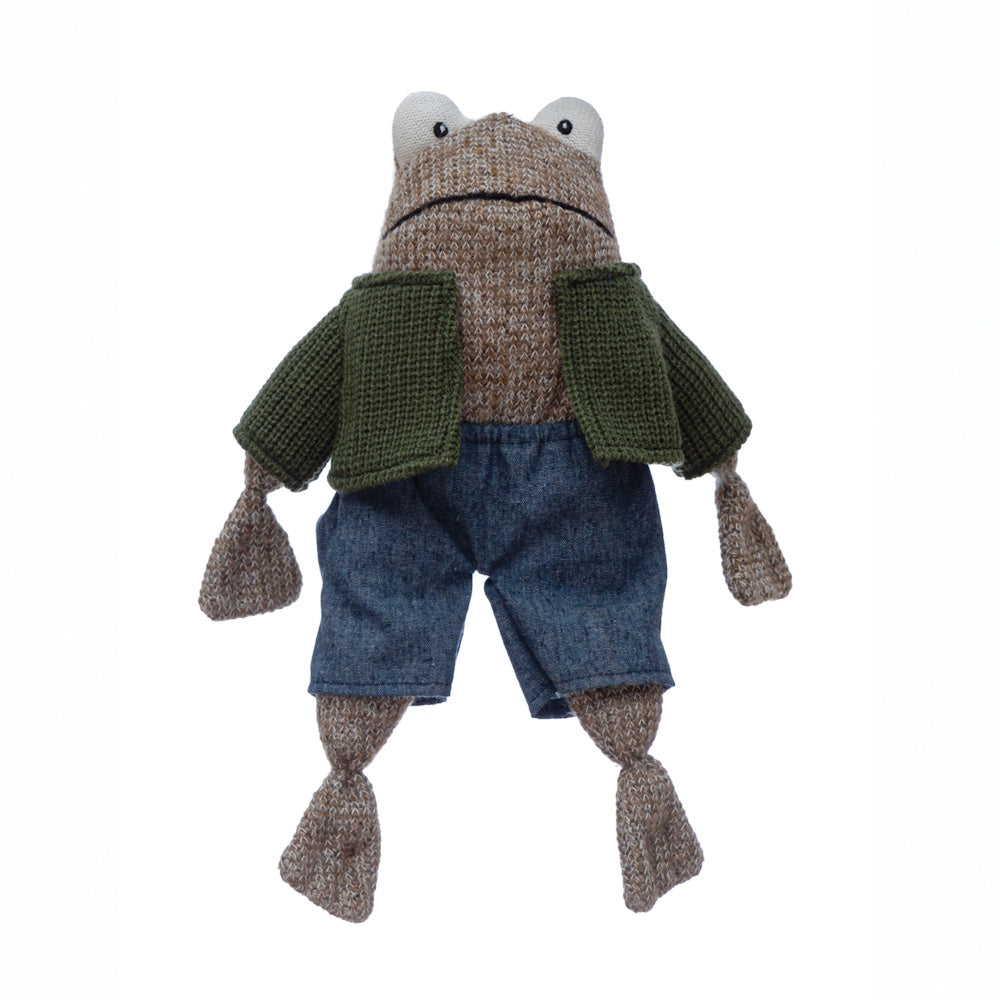 A knitted brown frog plush toy wearing a green cardigan and blue denim shorts on a white background.