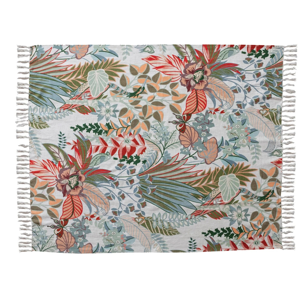 Cotton printed throw blanket with tropical botanical patterns, vibrant flowers, and fringed edges on a white background.