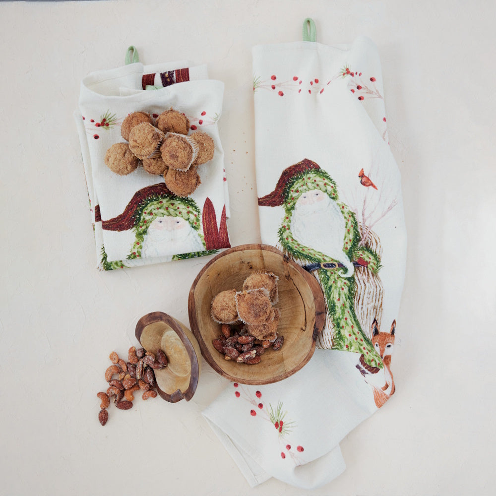 Lifestyle display of cotton slub printed Christmas tea towels styled with wooden bowls filled with baked treats and nuts.