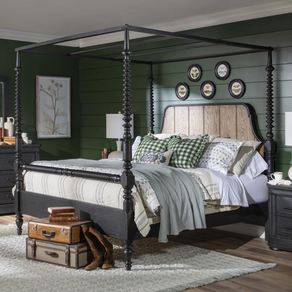 Black bobbin post canopy bed with a wood headboard, styled in a cozy bedroom with layered bedding.