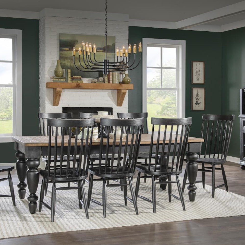 Dining room with rectangular wood top table, black chimney legs, spindle-back chairs, and chandelier overhead.