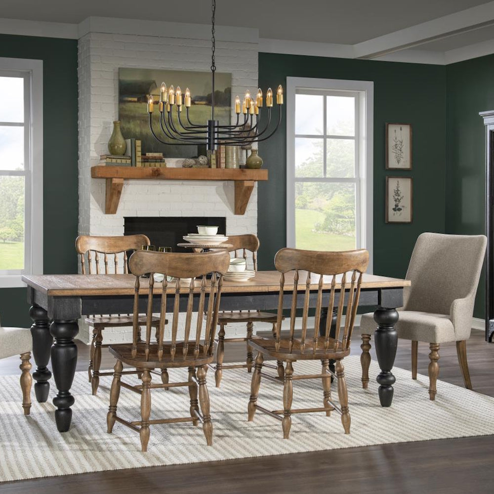 Dining room with rectangular wood top table, black turned legs, spindle-back chairs, and upholstered end chairs.
