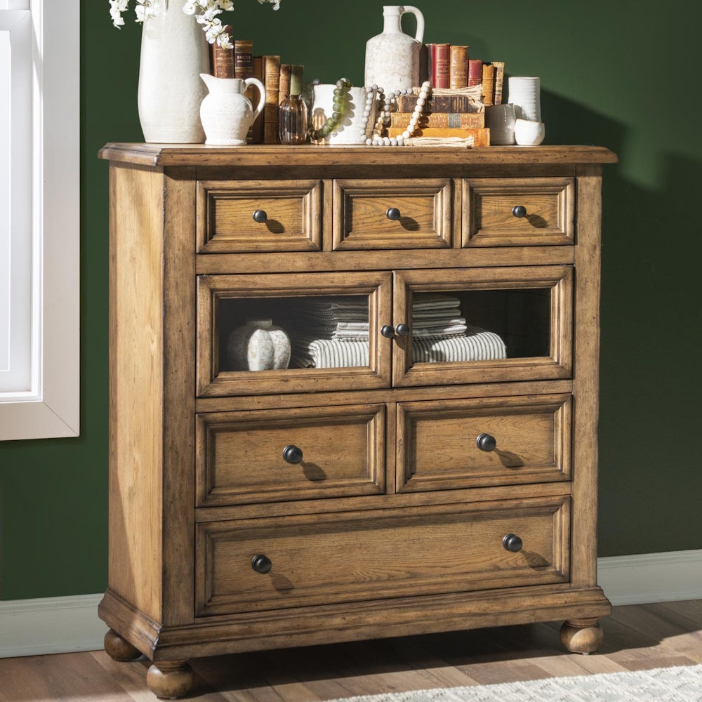 Rustic wood chest with glass cabinet doors, multiple drawers, and decorative items on top.