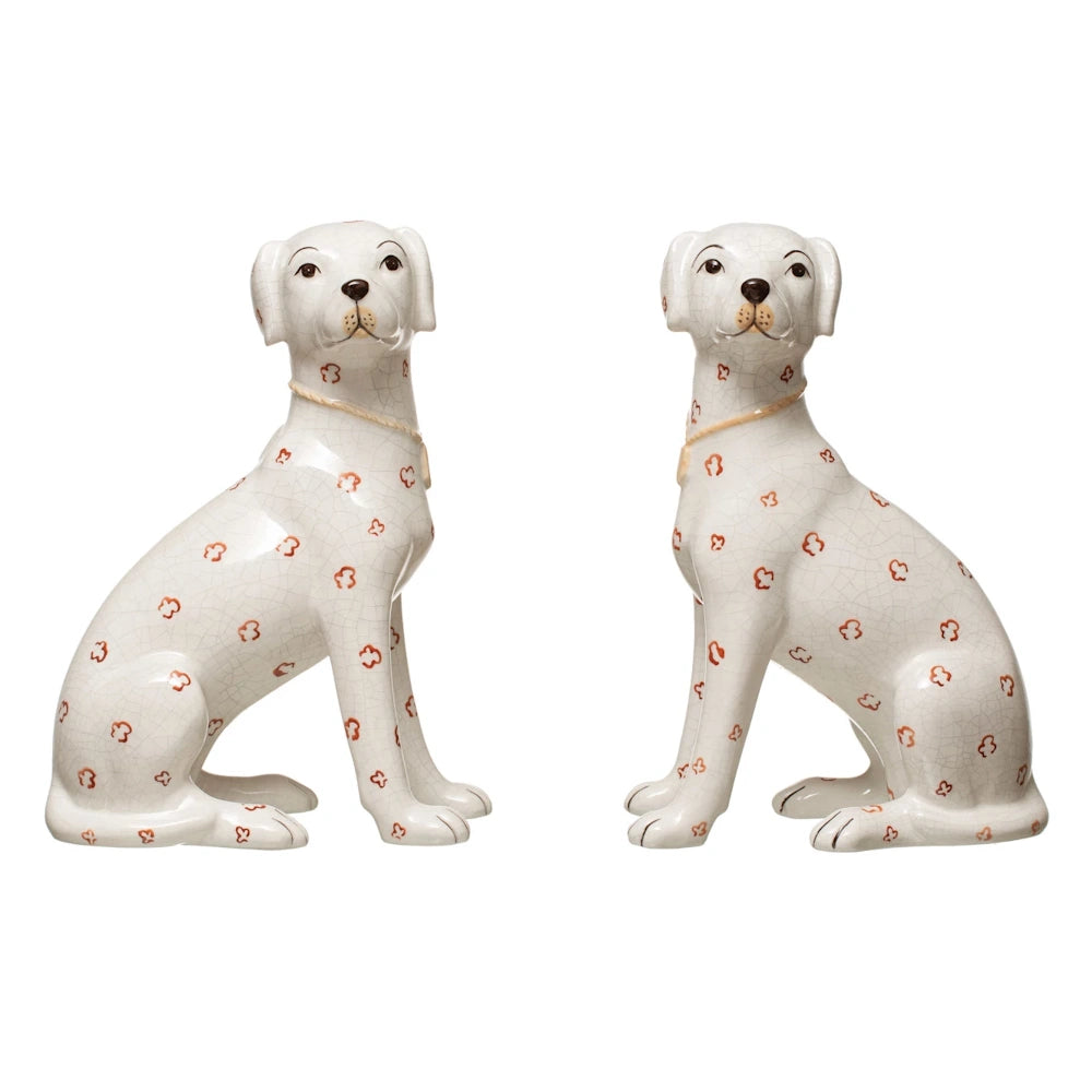 Hand-painted white ceramic dog figurines with crackle glaze and red clover patterns on a white background.