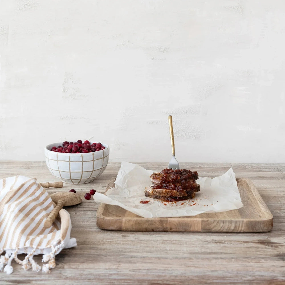 Sliced roast topped with cranberry chutney, served on parchment paper alongside fresh cranberries.