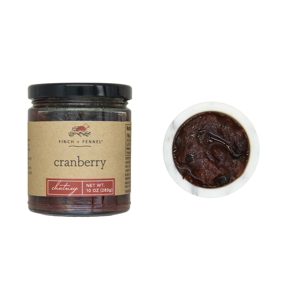 Jar of cranberry chutney next to a small bowl filled with chutney.