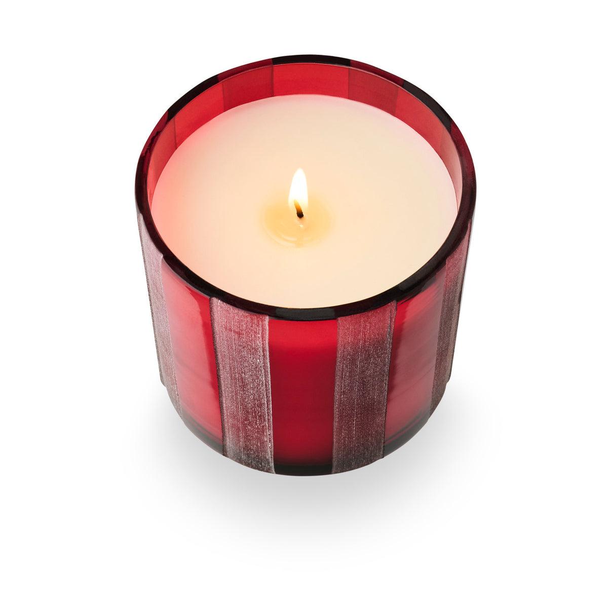 Top-down view of a lit candle in a translucent red etched-stripe glass jar.