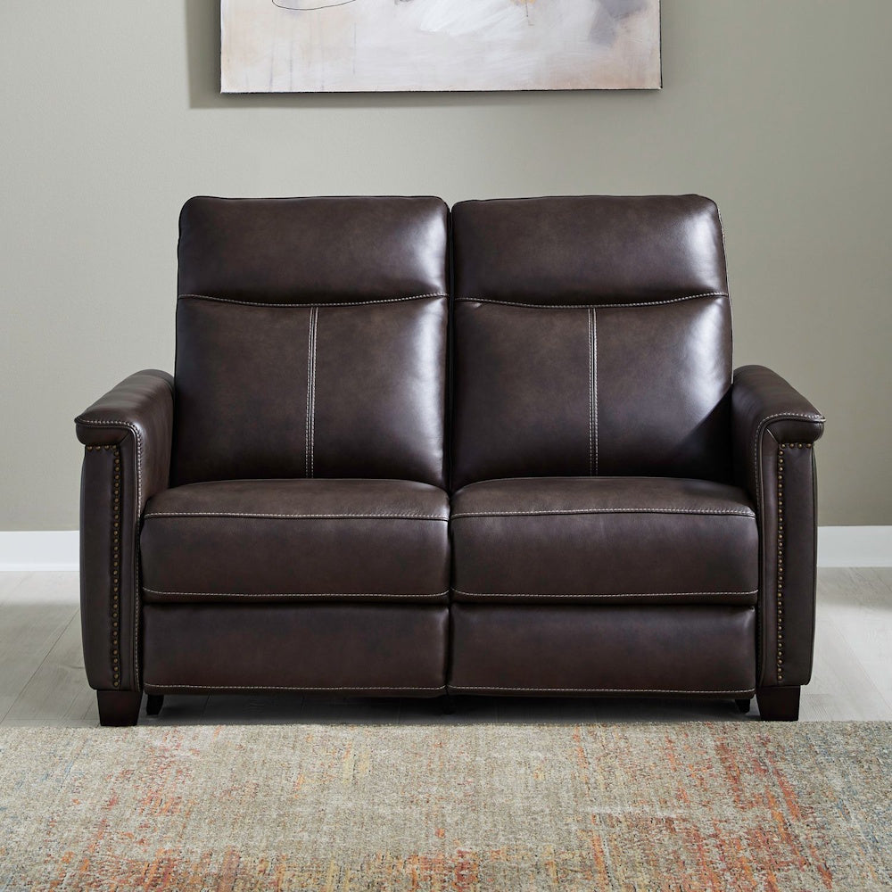 Dark brown leather loveseat recliner with nailhead trim in a modern living room.