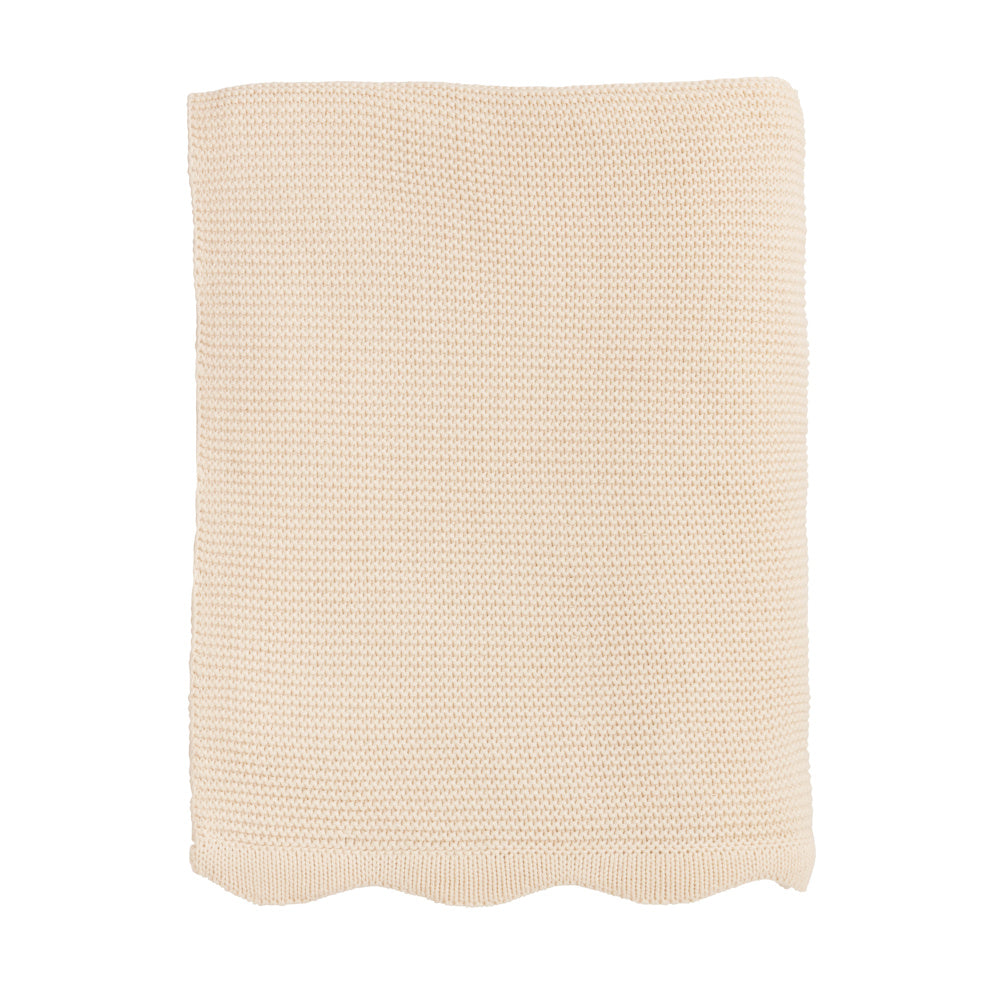 Cream scalloped edge knit throw blanket in a soft beige cotton, isolated on white. High-quality cozy home decor textile.
