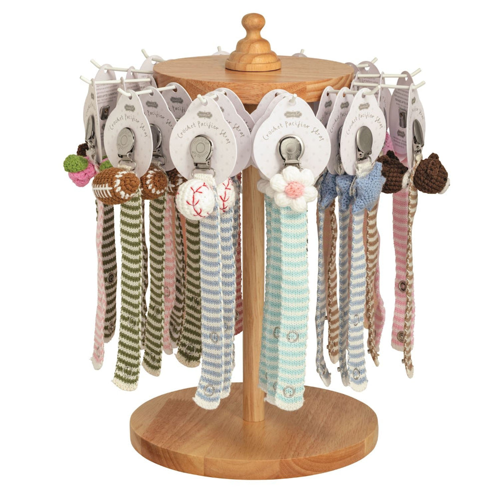 Wooden carousel display featuring various crochet pacifier clips with sports, flower, and animal designs on a white background.