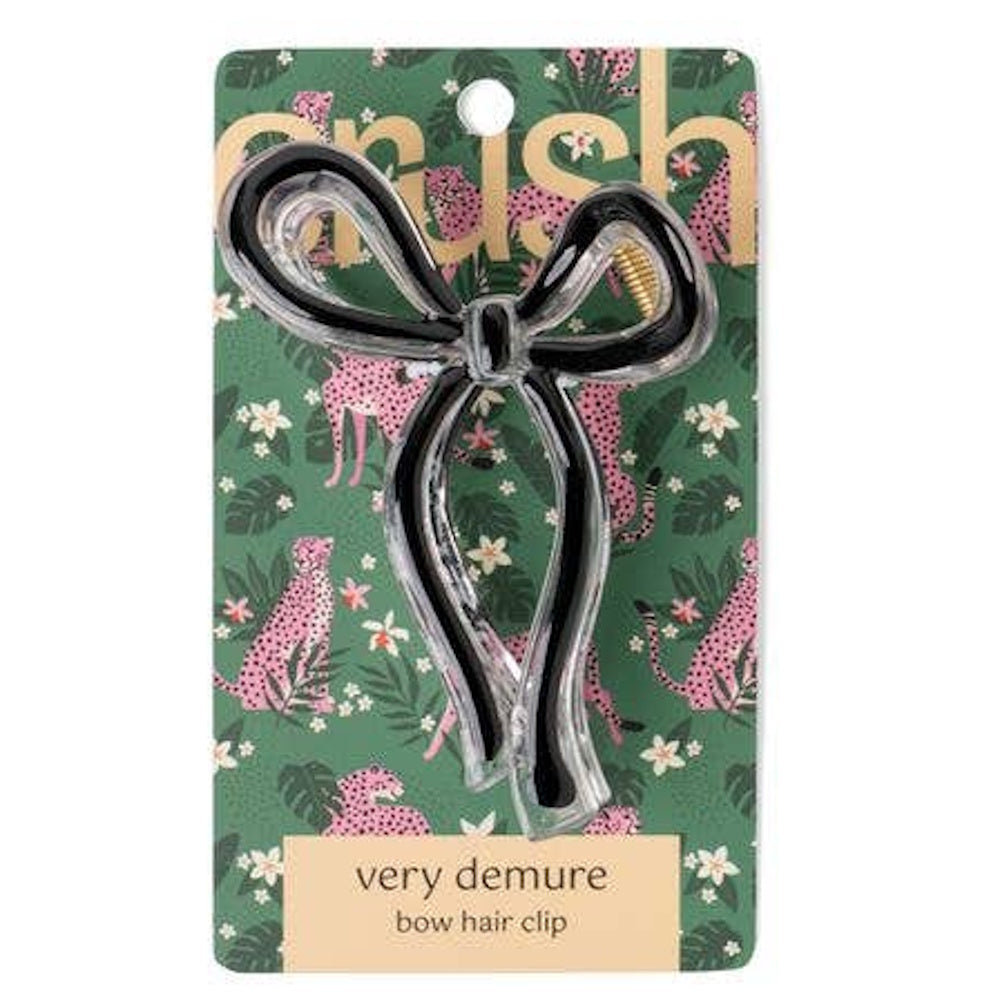 Clear acrylic bow hair clip with black outline detail on a pink cheetah print decorative card.